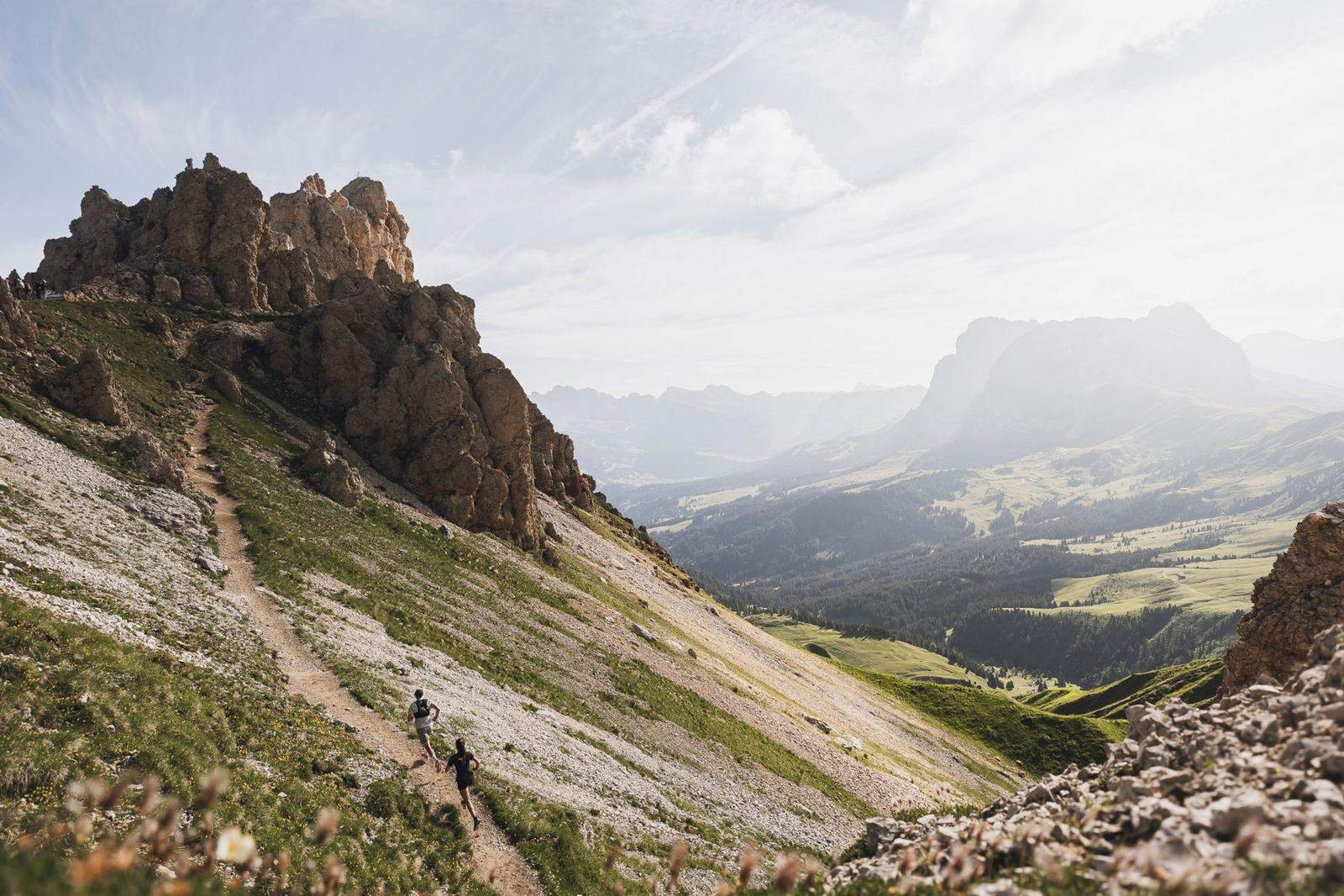 Zwei Trailläufer auf einem Bergpfad über der Seiser Alm